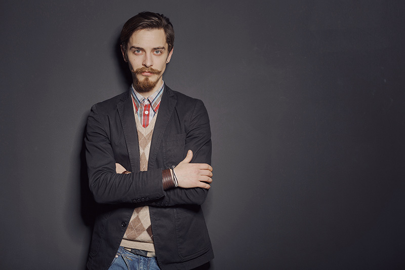 Man with light brown hair and crossed arms in sport jacket