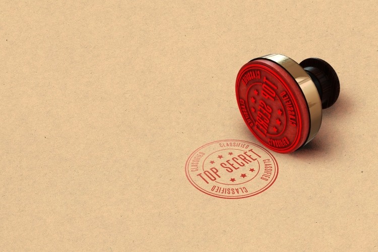 Red 'top secret' stamped onto light brown form beside adjacent stamper