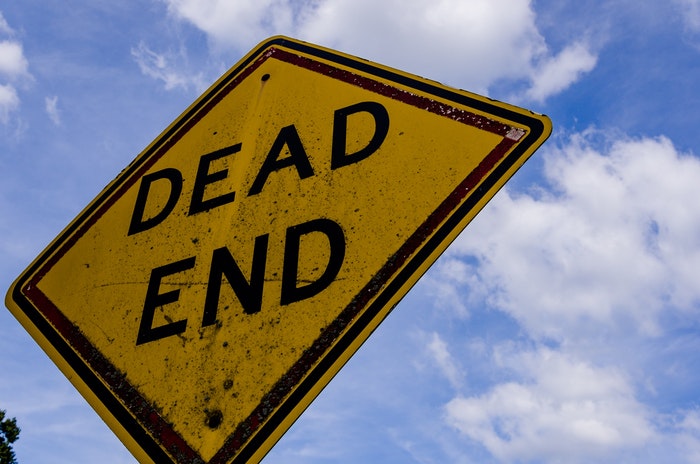 Road sign saying "dead end" and background of cloudy sky
