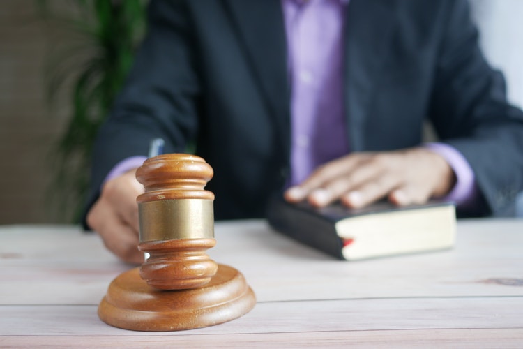 Judge-pounding-gavel with hand on bible