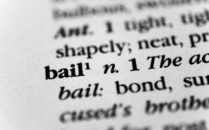 Close-up of the word 'bail' in dictionary with beginning of adjacent definition