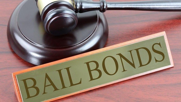 Bail Bonds sign and gavel on judge's mahogany desk