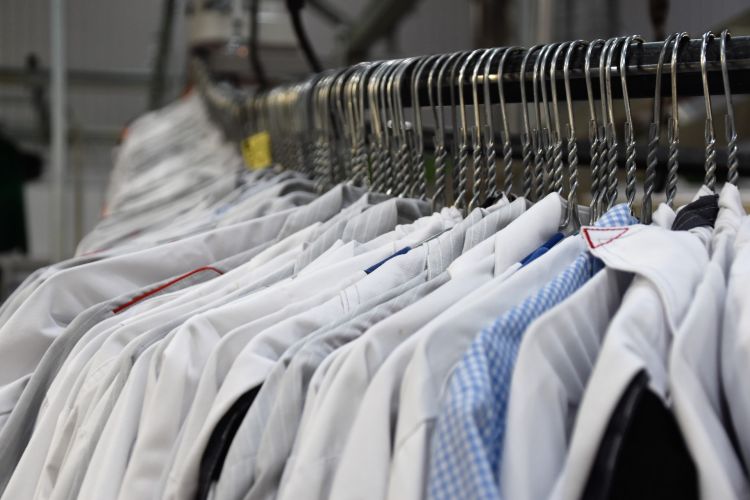 Clothing rack with white dress shirts on wire hangers