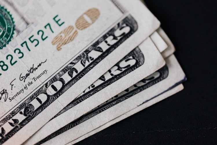 Stack of twenty dollar bills viewed close-up with black background