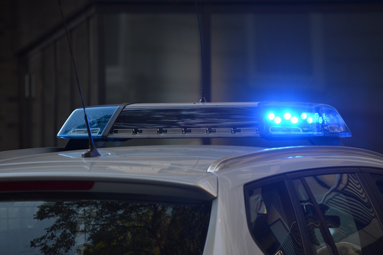 Flashing blue lights on white police car at night